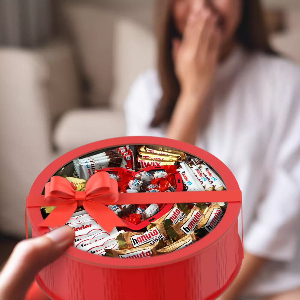 Frau freut sich über rote Geschenkbox mit Herzfach und Schokolade – emotionale Geschenkidee für besondere Momente.