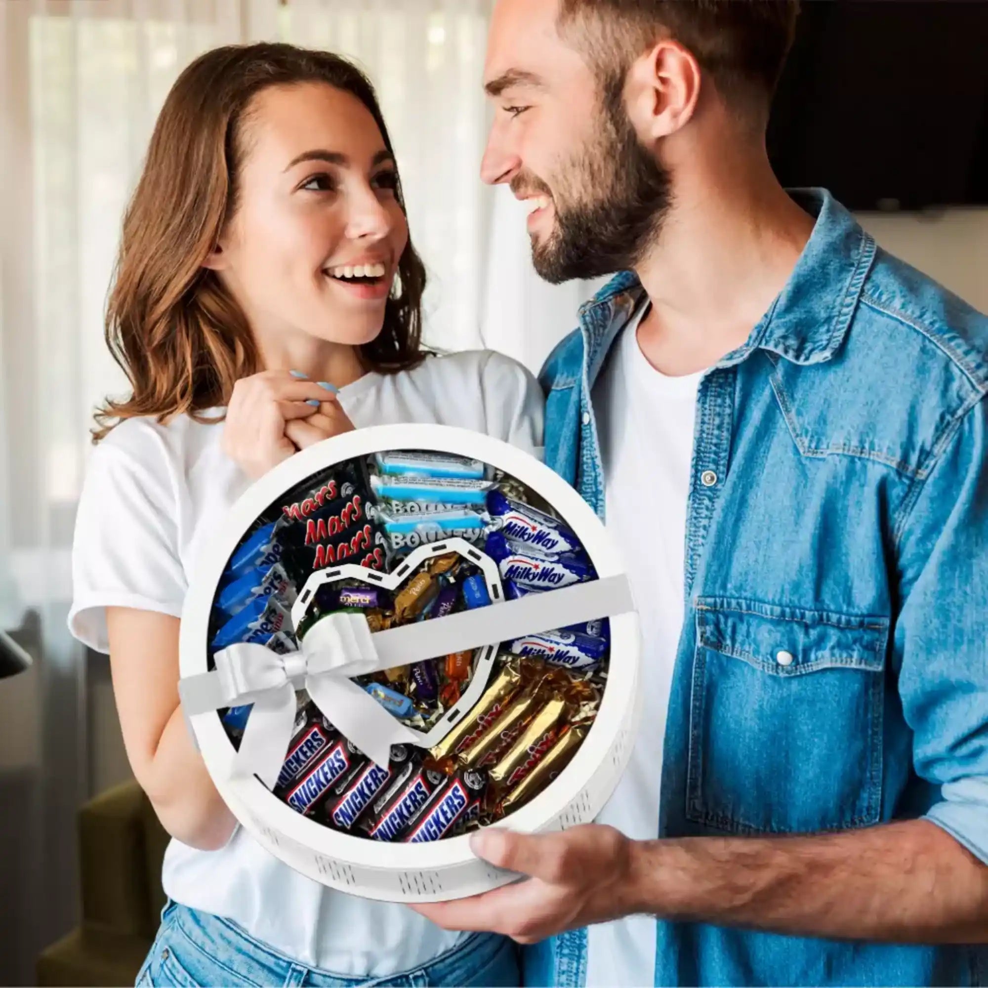 Glückliches Paar hält runde Geschenkbox mit Herzmotiv – perfekte Idee für Partner, Freunde oder Familie.