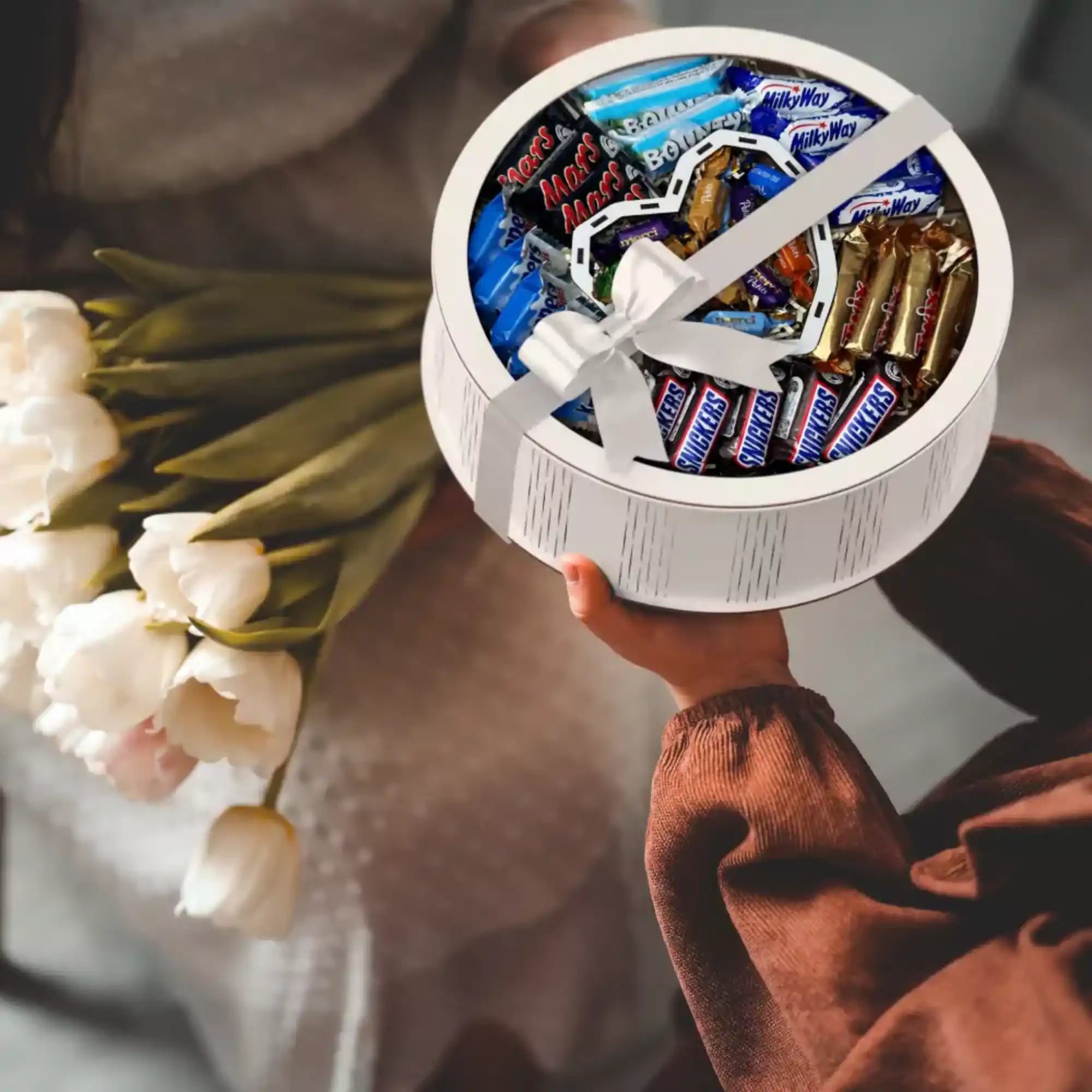 Person überreicht elegante Herz-Geschenkbox mit Blumen – liebevolle Aufmerksamkeit zum Geburtstag oder Valentinstag.